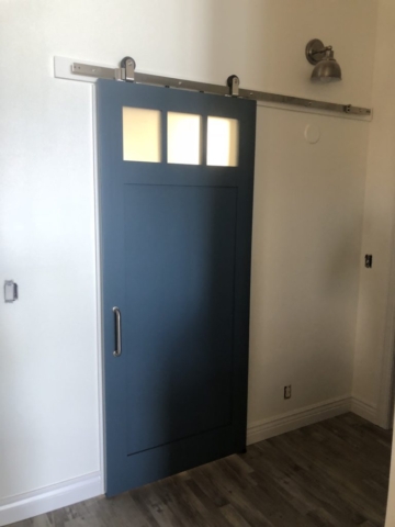 blue sliding interior barn door with windows and modern handle