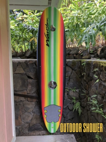outdoor shower made from brightly colored surfboard outside