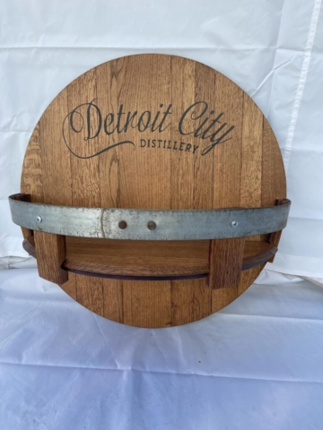 a wooden barrel shelf with "Detroit City Distillery" on it