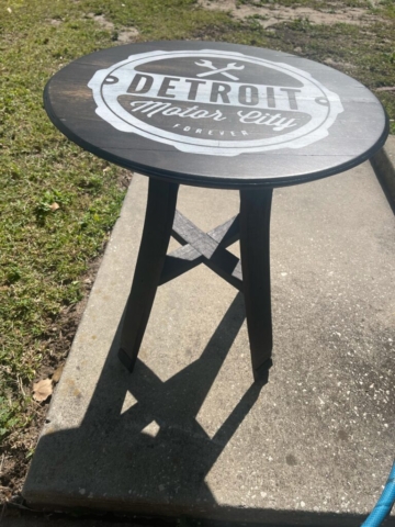 whiskey barrel table with Detroit logo on top on a sidewalk